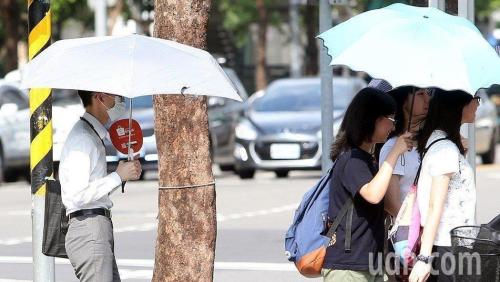台湾民众打伞遮阳防暴晒。台湾《联合报》资料图