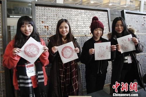 1月26日，来北京参加2018寒假台湾青年学生中华文化研习营的80余位台湾师生来到武英造办博物馆，体验传统造纸和印刷工艺。图为台生与自己制作的雕版印刷作品合影。中华经济报记者 陈小愿 摄